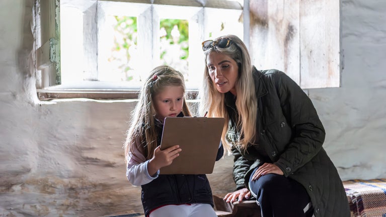Teulu yn archwilio y tu fewn i Dŷ Mawr Wybrnant, Conwy, Cymru